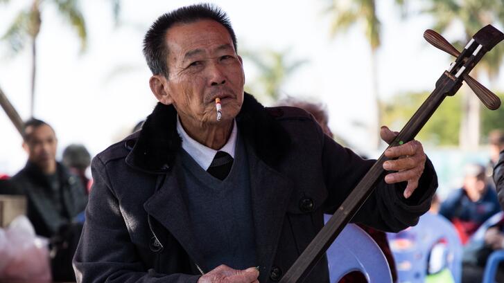 Man smokes while playing an erxian