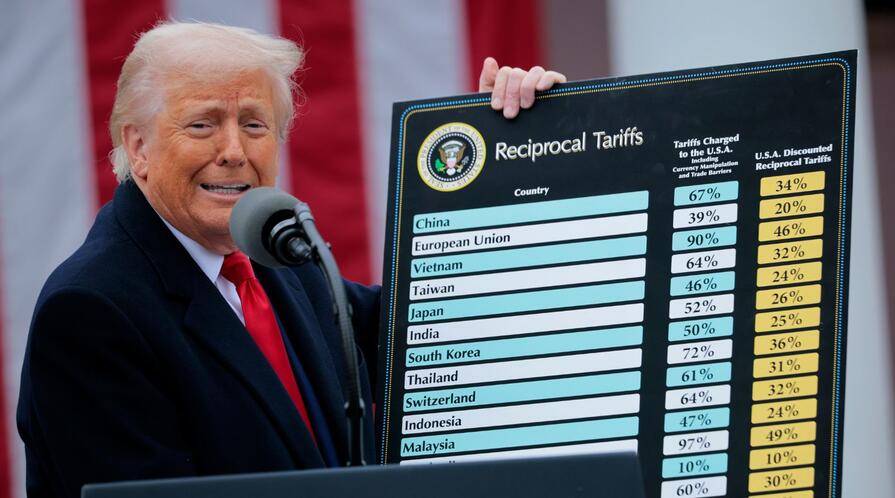 U.S. President Donald Trump holds up a chart of "reciprocal tariffs" while speaking