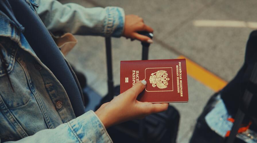 Woman holding Russian passport with luggage