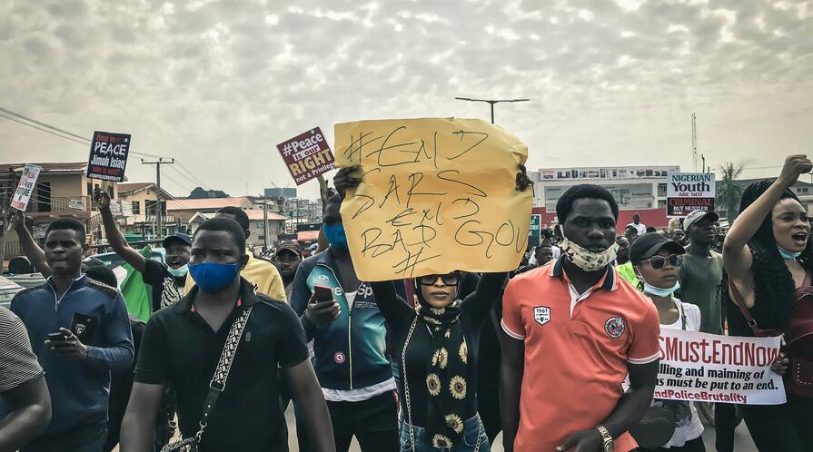 Group of people protesting in Ibadan, Nigeria, holding a sign reading "#EndSARS #EndBadGov"