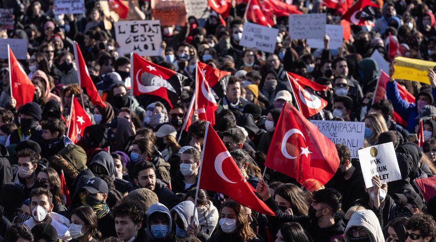 Protesters chant slogans during a protest march holding Turkish flags
