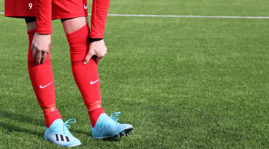 A person in a red and blue football uniform on a field