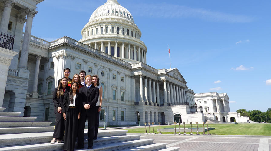 Several students pose on the steps of the U.S. Capitol following the final site visit of Honors College.