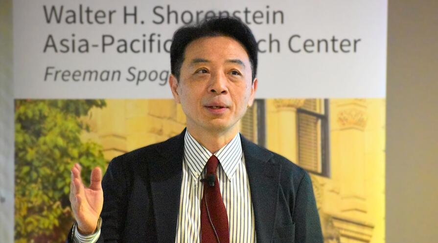 Weitseng Chen presents at a lectern.