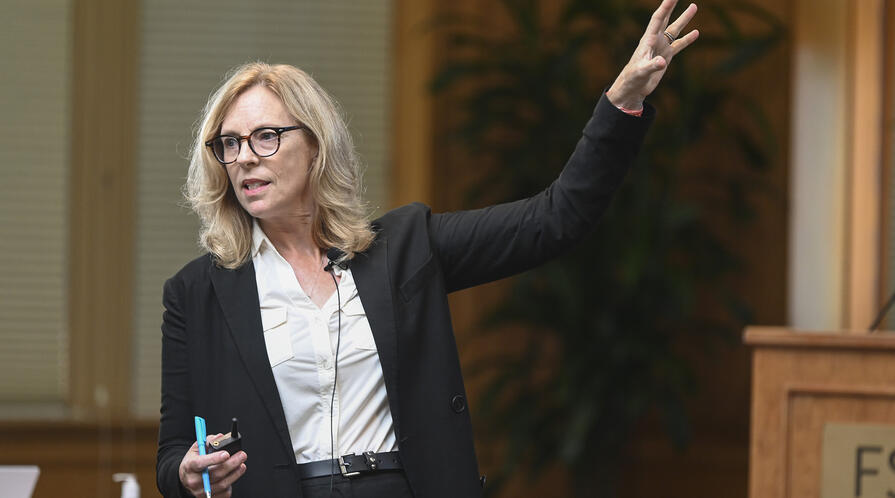 Kathryn Stoner gestures toward the screen during a lecture in Encina Hall