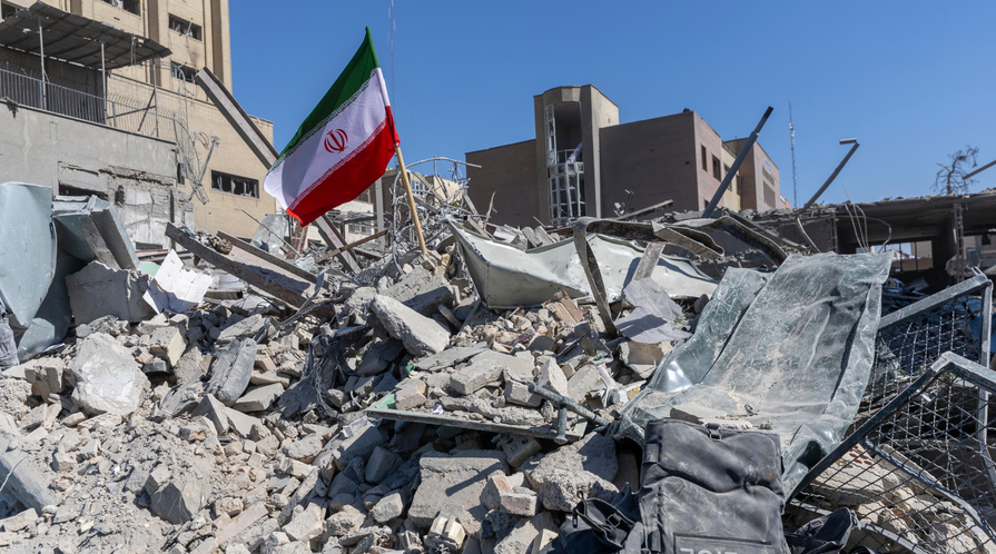 An Iranian flag is planted in the rubble of a police station, damaged in airstrikes on March 3, 2026 in Tehran, Iran.