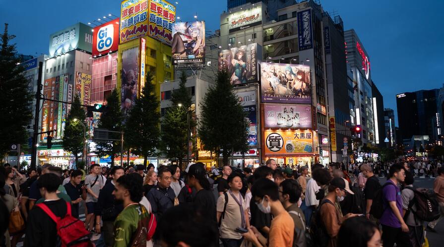 People cross a road in the Akihabara district in Tokyo, Japan.