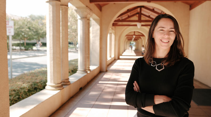 Stanford's Maria Polyakova stands amid the university's sandstone columns.