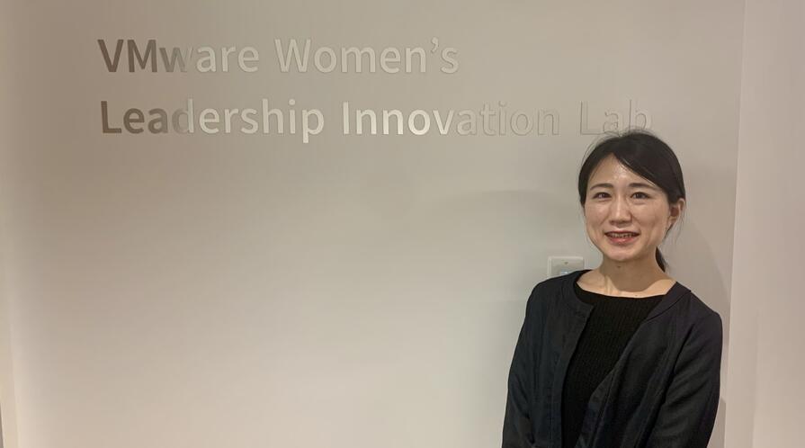 a student posing in front of a sign