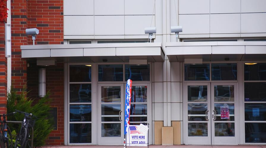 Building with glass doors and polling station signage out front