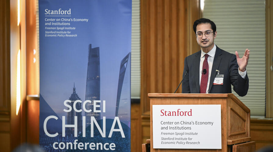 Rush Doshi speaks behind a podium at the SCCEI China Conference