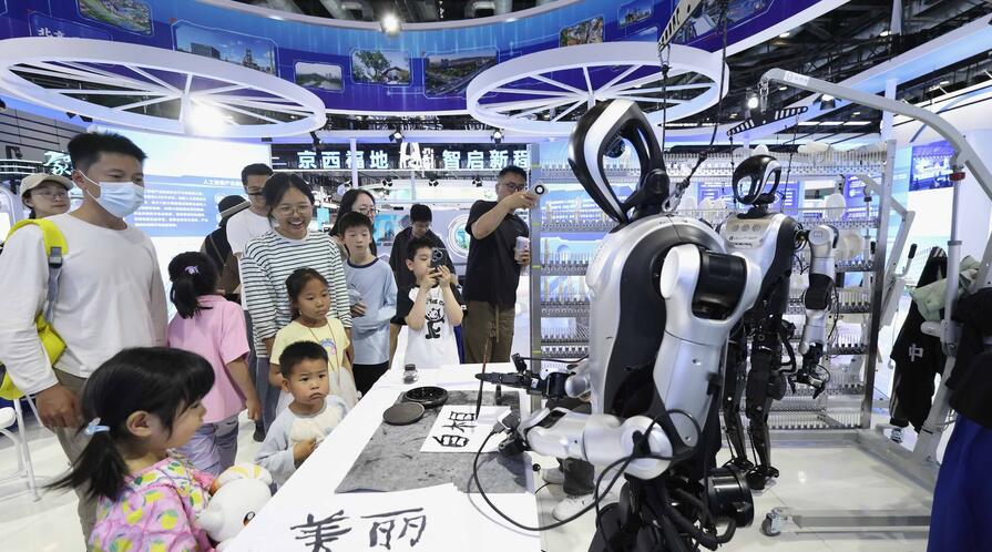 Visitors watch humanoid robots writing calligraphy during the 28th China Beijing International High-Tech Expo at China National Convention Center on May 9, 2026.