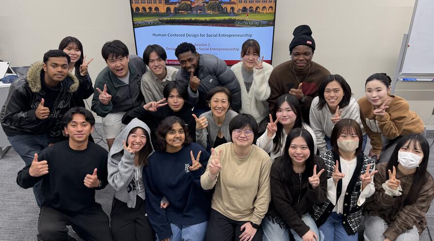 group of students posing in front of a screen