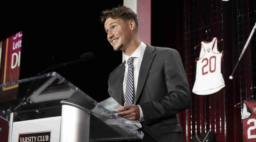 Ni White in a suit and tie giving a speech at a podium at Harvard University