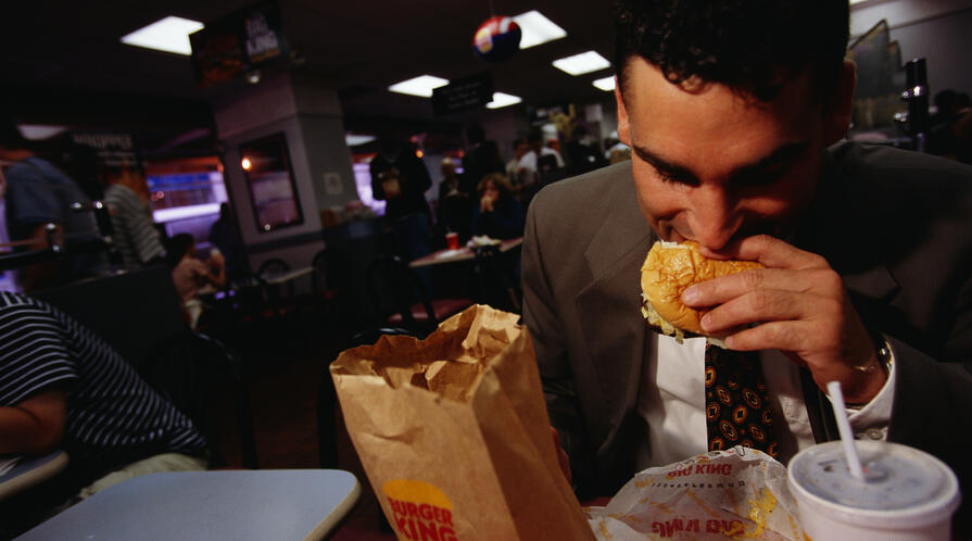 A man eating a hamburger at Burger King