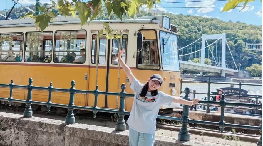 Young woman standing in front of a rail car