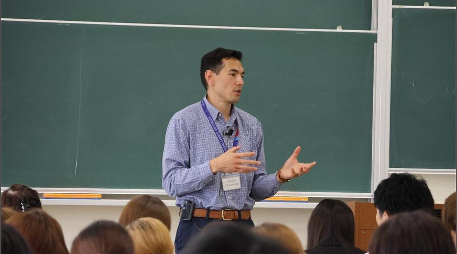 a person giving a talk in front of a class