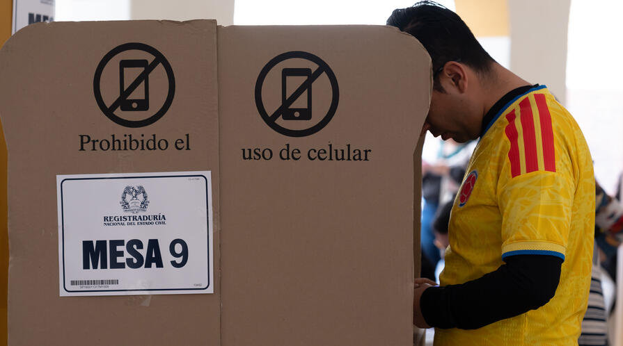 A man in a Colombian football jersey casts his vote in the presidential election on May 31, 2026, in Bogotá, Colombia.