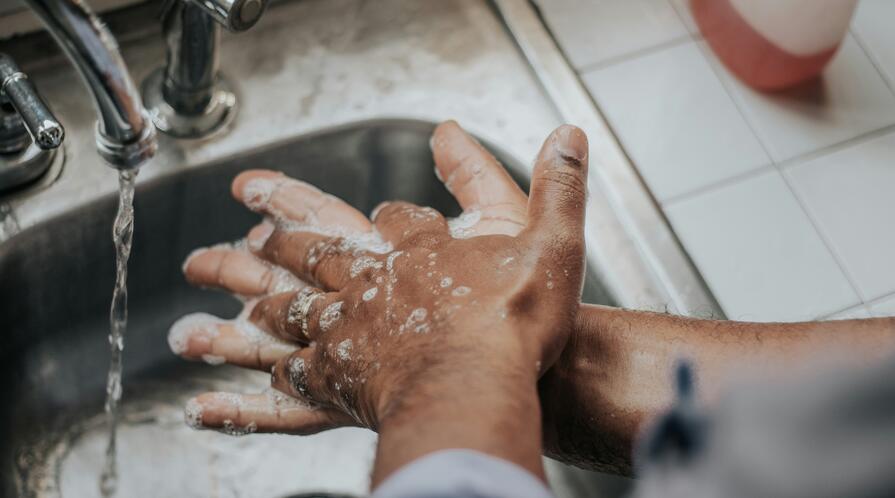 Person in blue shirt washing hands