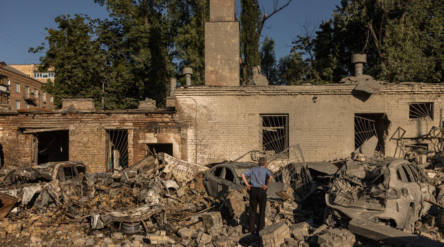 Residents walk through debris in a courtyard following a Russian missile strike on August 20, 2026, in Kyiv, Ukraine.