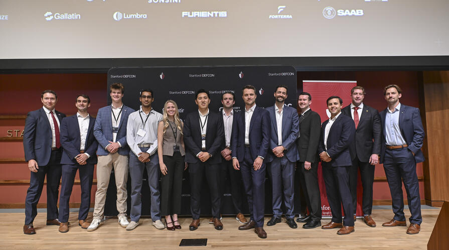 Student organizers pose together on stage at the 4th Annual Stanford Conference on Technology and National Security