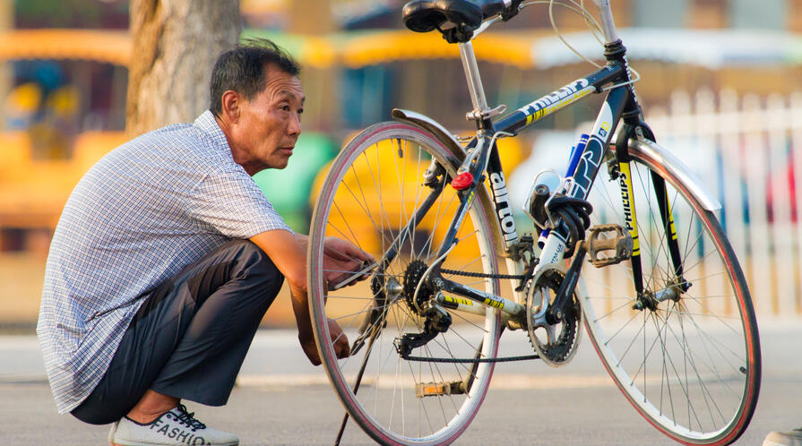 An older man sits alongside his bike in Beishan Park, Dongbei, China. flickr see ming lee senior bike dongbei china