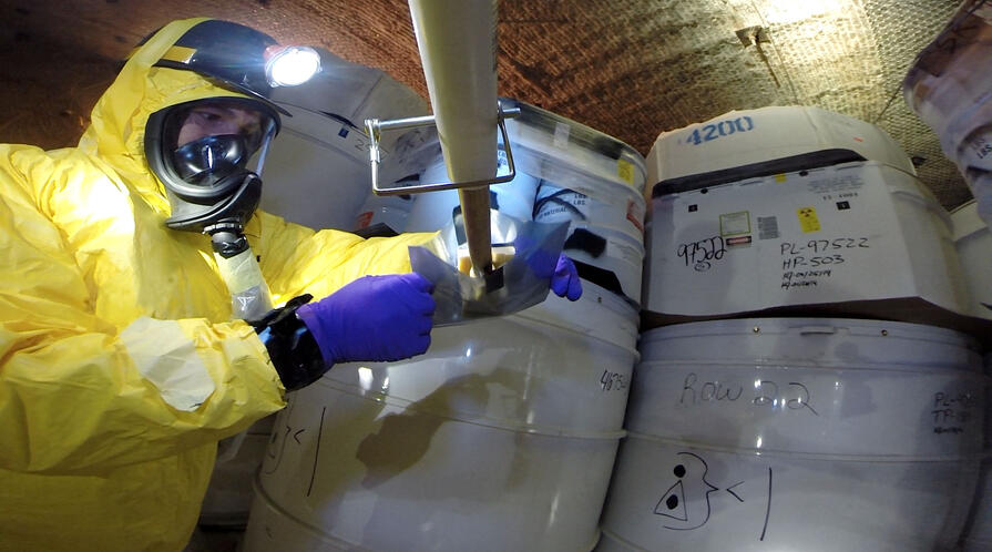 A recovery worker obtains samples from a damaged drum after a radioactive leak at the Waste Isolation Pilot Plant in Carlsbad, New Mexico in May, 2014.