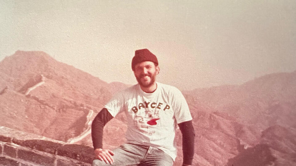 person in white shirt and black beanie sitting