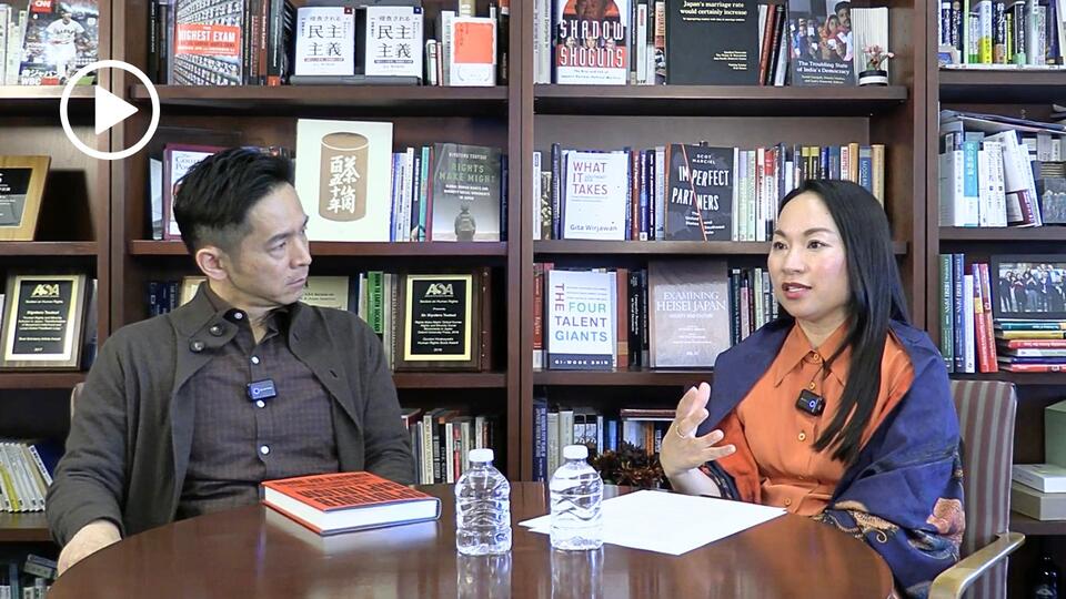 Kimberly Hoang and Kiyoteru Tsutsui seated in an office during a recorded podcast conversation.